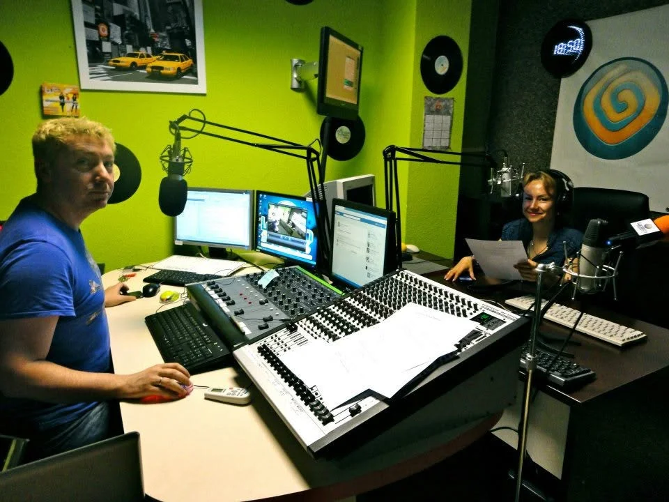Dos personas en estudio de radio con micrófonos y equipo de sonido